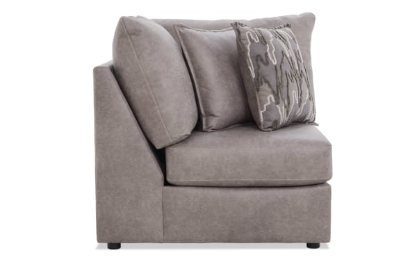 Modern gray fabric corner sofa section with plush cushions and patterned accent pillow, ideal for living room seating and comfort.
