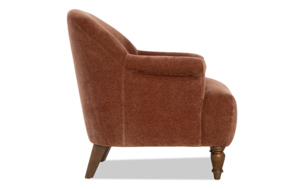 Mid-century modern armchair with rust-colored velvet upholstery, wooden tapered legs, and a cushioned seat and backrest for living room seating.