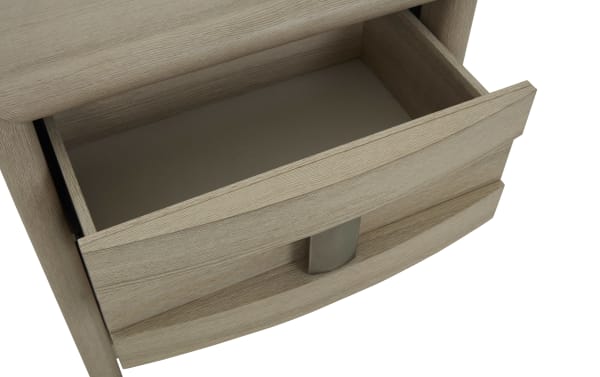 Light wood grain nightstand drawer with curved front panel and brushed metal handle, showcasing smooth sliding mechanism and spacious interior.