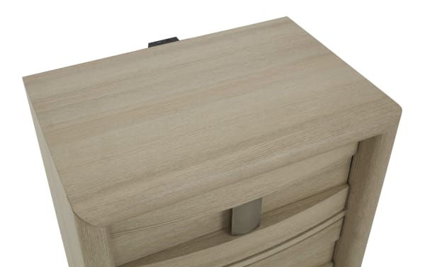 Light wood-finished dresser top with smooth rounded edges and a metallic handle on the drawer, showcasing modern bedroom furniture design.