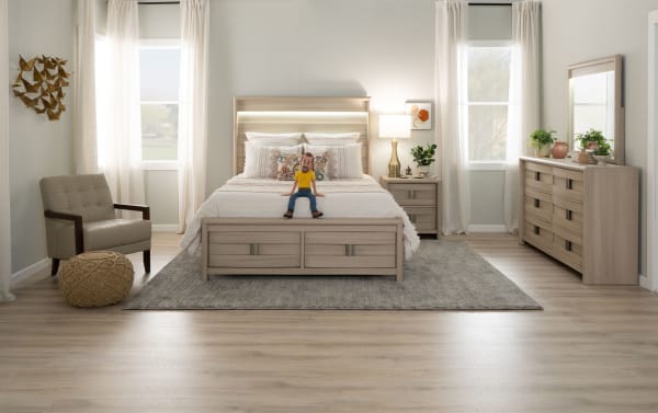 Open wooden drawer with a light oak finish and metal handle, showcasing storage space in a modern bedside table or dresser.