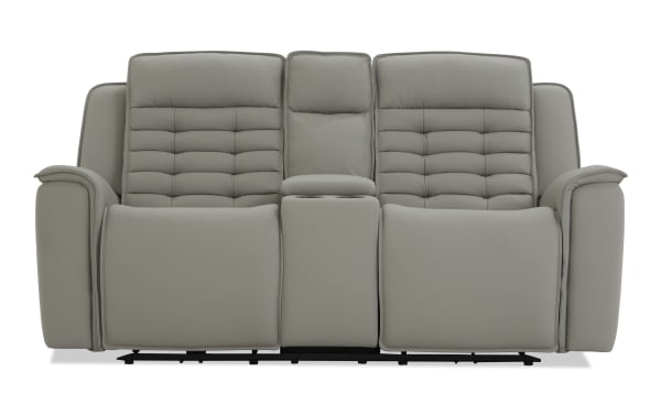 Gray leather reclining loveseat with padded armrests, tufted back cushions, and center console with cup holders, modern style.