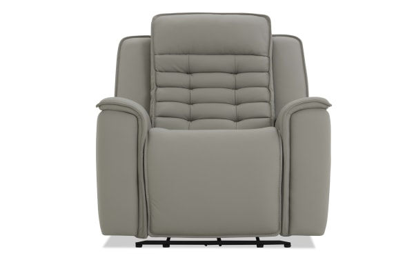 Modern gray leather recliner chair with padded armrests, cushioned backrest, and stitched detailing, designed for comfort and relaxation.