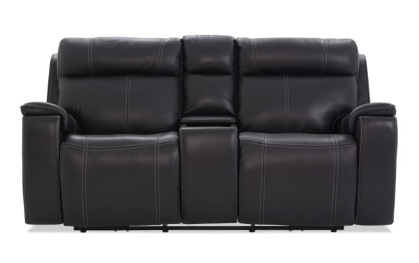 Black leather reclining loveseat with contrast stitching, padded armrests, and a center console for storage or cup holders, ideal for home theater seating.