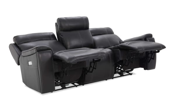 Black leather reclining sofa with double stitching, featuring two extended footrests and padded headrests, designed for comfort and relaxation.