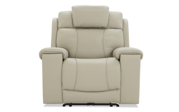 Beige leather recliner chair with padded armrests, cushioned headrest, and ergonomic stitching, designed for comfort and relaxation.
