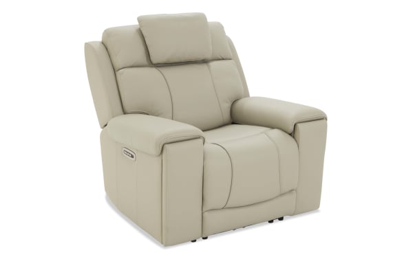 Beige leather recliner chair with padded armrests, cushioned backrest, and built-in side control panel for reclining adjustment.
