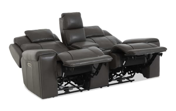 Dark gray leather power reclining loveseat with adjustable headrests, padded armrests, center console, and USB charging ports, designed for comfort and modern living rooms.