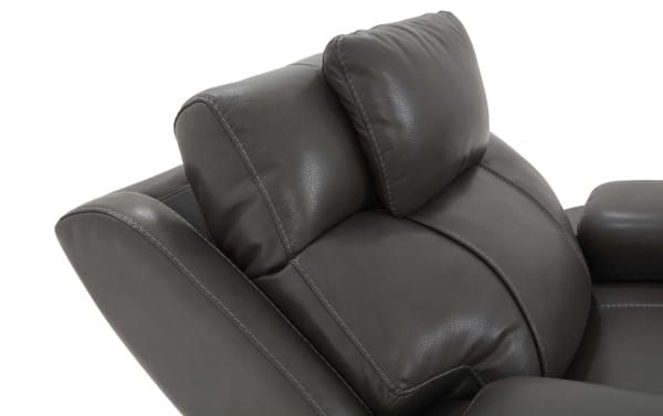 Dark brown leather recliner chair backrest with plush padded headrest and detailed stitching, highlighting comfort and modern design.
