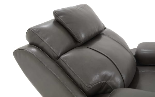Dark brown leather recliner chair backrest with cushioned headrest and detailed stitching, showcasing comfort and premium upholstery.