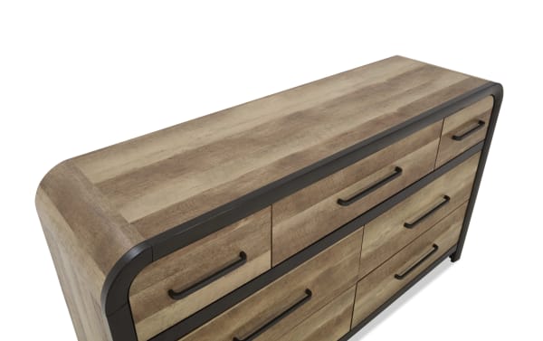 Wooden dresser with a natural brown finish, black metal handles, and rounded edges, featuring multiple drawers for bedroom storage.