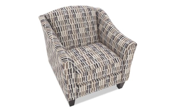 Upholstered accent chair with patterned fabric in beige, brown, and black tones, featuring a cushioned seat and tapered wooden legs.