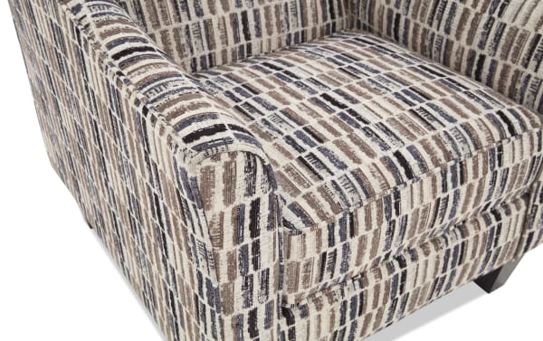 Upholstered armchair with a textured fabric featuring a geometric pattern in beige, brown, and black tones, showcasing a modern design and cushioned seat for comfort.