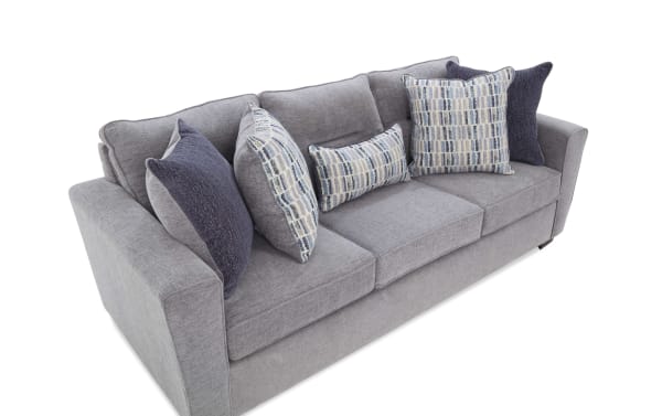 Modern gray fabric sofa with plush cushions and patterned blue and white throw pillows, featuring a contemporary design and soft upholstery.