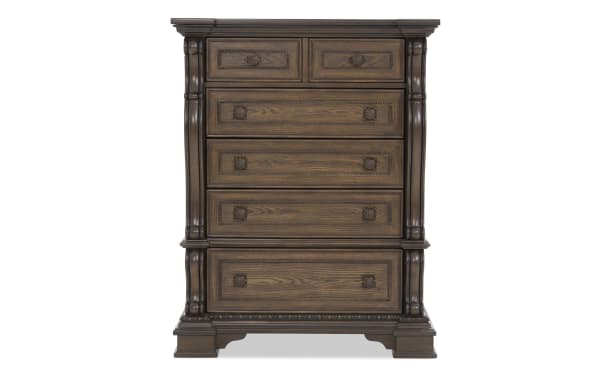Traditional wooden chest of drawers with dark brown finish, ornate carved details, and five drawers with decorative metal handles, ideal for bedroom storage.