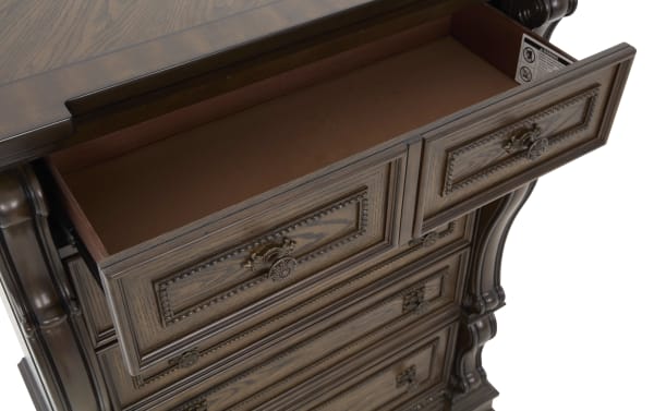 Dark wood dresser drawer open showing spacious interior, ornate carved details, and antique brass handles, highlighting classic furniture design.