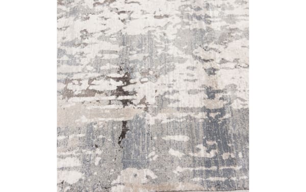 Area rug with an abstract pattern in shades of gray, beige, and white, featuring a textured, modern design suitable for contemporary interiors.