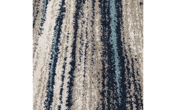 Plush area rug with a textured, looped pile featuring an abstract striped pattern in beige, navy blue, and light blue tones.