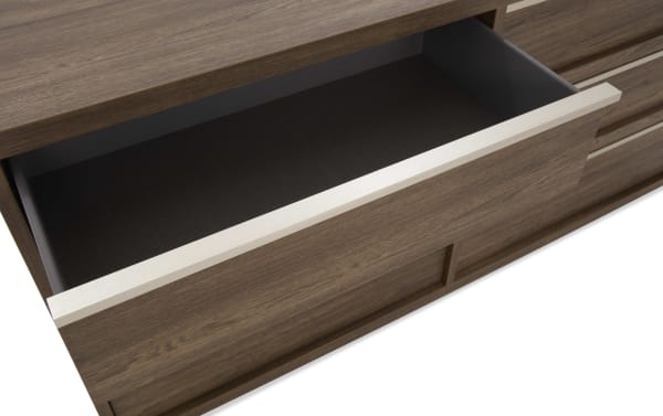 Open wooden drawer with dark interior and light-colored horizontal handle, part of a modern brown wood dresser or cabinet.