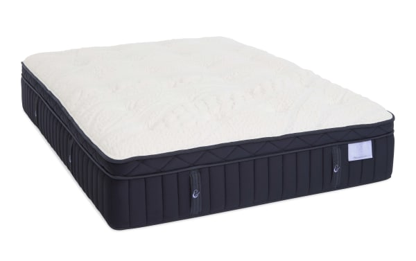 Plush Crescent Cloud mattress with quilted white top and navy blue sides, featuring vertical stitching and fabric handles for easy moving.