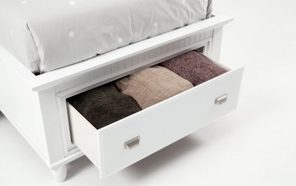 White Spencer Twin Storage Platform Bed drawer open, showing neatly folded knit blankets inside. Transitional style with hardwood, MDF, plywood, and poplar solids.