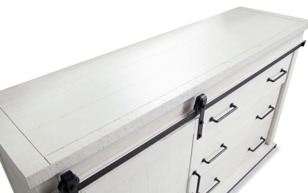 Montana White 5 Drawer Dresser in rustic white finish, made of MDF, pine solids, and pine veneer, featuring black metal handles and sliding barn door hardware for bedroom storage.