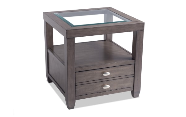 Prestige Gray Storage End Table from Prestige Occasional collection, transitional style with solid acacia, MDF, platinum finish, beveled glass top, oval metal handles, one drawer, and open shelf for storage.
