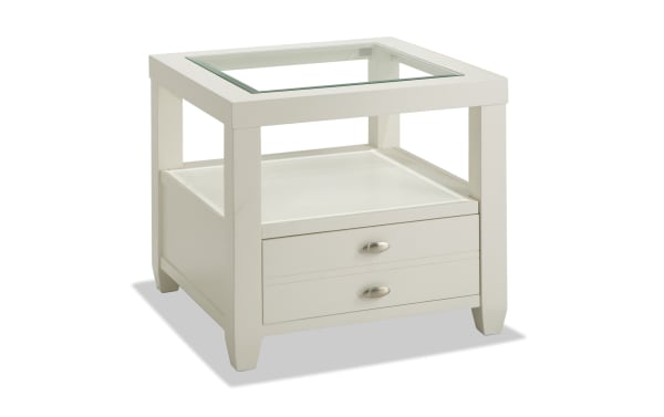 Prestige White Storage End Table from Prestige Occasional collection, transitional style with solid acacia, MDF, beveled glass top, oval metal handles, and spacious drawer.