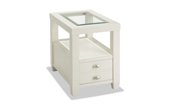 Prestige White Storage Chairside Table from Prestige Occasional collection, transitional style with white solid acacia, MDF, beveled tempered glass top, oval metal handles, one drawer, open shelf, and built-in USB ports and power outlets.