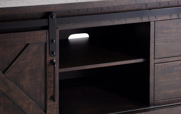 Rustic Montana 65'' brown TV stand with pine solids, MDF, and pine veneer. Features sliding barn door, open shelving, and storage drawers.