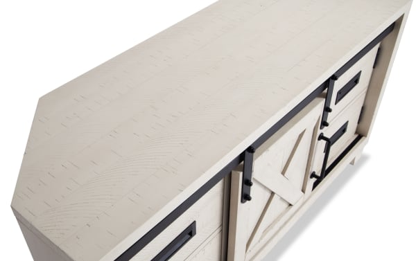 Montana 48'' white rustic corner TV stand with pine solids, MDF, pine veneer, sliding barn door, drawers, and black metal handles for storage.