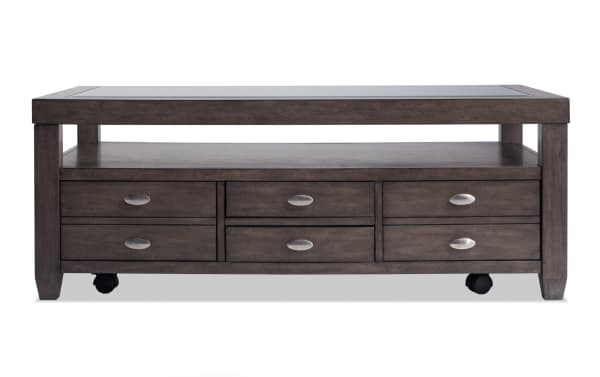 Prestige Gray Storage Coffee Table from Prestige Occasional collection, transitional style with solid acacia, MDF, glass top, beveled edges, casters, open shelf, and six storage drawers.
