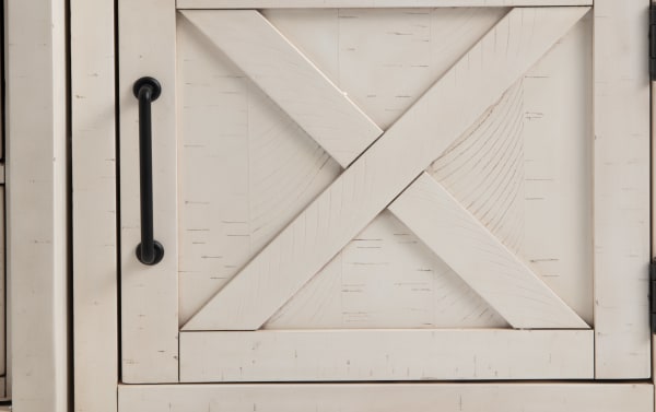 Rustic white pine wood cabinet door with black metal handle from Montana 109'' White 4 Piece Entertainment Center, featuring crossbeam design and distressed finish.