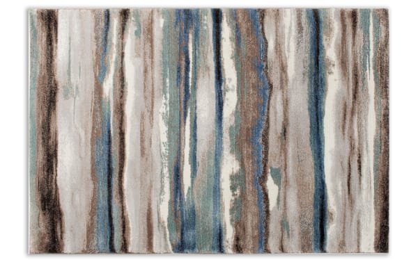 Area rug with an abstract vertical stripe pattern in shades of blue, brown, beige, and cream, featuring a soft, plush texture suitable for modern home decor.