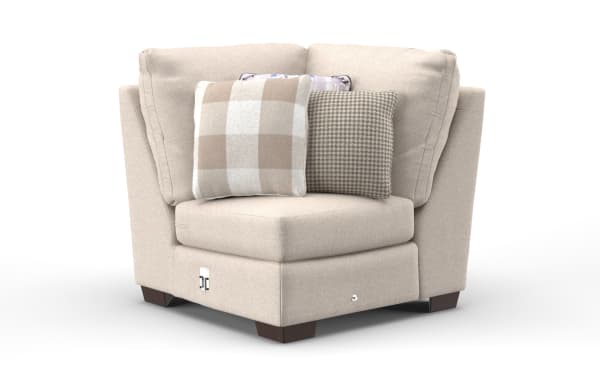Beige fabric corner armchair with plush cushions and three decorative pillows in plaid, houndstooth, and floral patterns, featuring dark wooden legs.