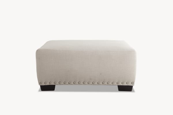 Beige Cottage Chic Ottoman with traditional style, polyester fabric upholstery, subtle gingham pattern, and decorative nailhead trim.