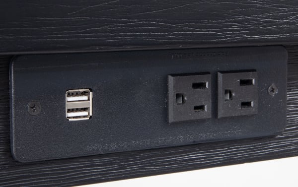 Black power outlet panel with two standard electrical sockets and dual USB charging ports, integrated into a contemporary Elevations 4 Piece Black & Gray Upholstered Sofa Table Set for convenient device charging.