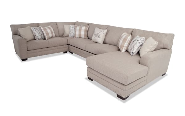 Beige Cottage Chic 150" 4-piece right arm facing chaise sectional with traditional design, polyester fabric, nailhead accents, and 10 patterned pillows.