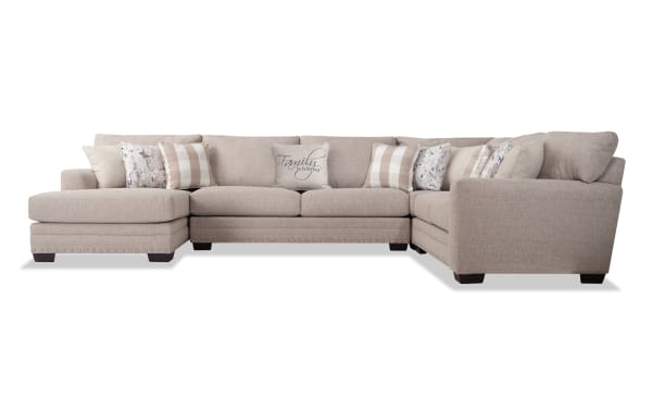 Beige Cottage Chic 150'' 4-piece left arm facing chaise sectional with traditional style, polyester fabric upholstery, nailhead trim, and 10 patterned accent pillows.