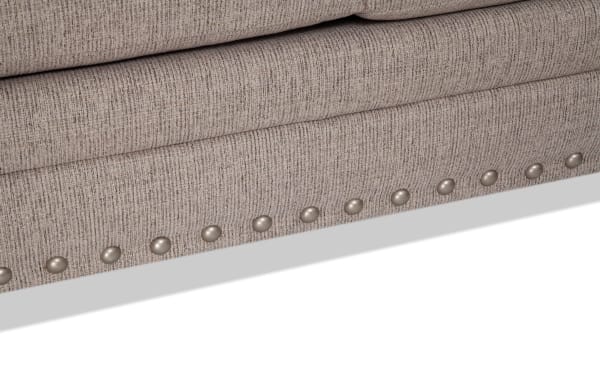 Beige polyester fabric chaise sectional with traditional nailhead trim detailing, part of the Cottage Chic collection, 150-inch length.