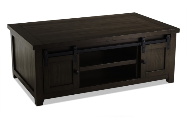 Rustic Montana Brown Storage Coffee Table from Montana Entertainment & Occasional collection, made of pine solids and plywood, featuring dark brown finish, gliding barn doors, black metal hardware, open central shelf, and sturdy legs.