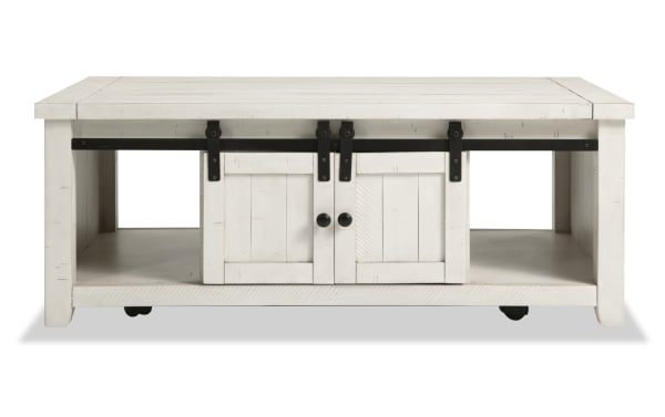 Rustic Montana White Storage Coffee Table from Montana Entertainment & Occasional collection, made of pine solids and plywood, featuring gliding barn doors, black metal hardware, open side shelves, and casters for easy mobility.