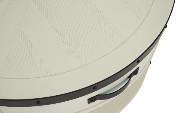 Round beige metal container with a black metal handle and decorative rivets, featuring a textured lid with a subtle wave pattern.