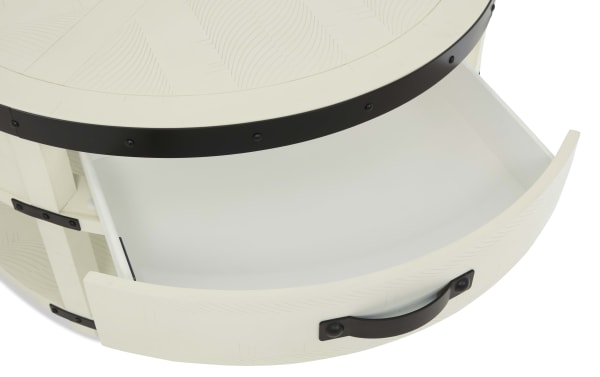 Round white wooden drawer with black metal handle and decorative black metal bands, showing open storage space inside.