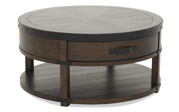Round wooden coffee table with dark metal accents, featuring a lower shelf and a single drawer with a metal handle, suitable for living room decor.
