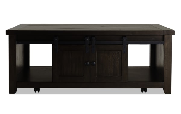 Rustic Montana Brown Storage Coffee Table with pine solids, plywood, sliding barn doors, black hardware, and open side shelves for storage.