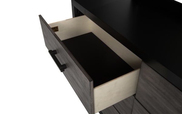 Open drawer of Fusion Black & Gray 6 Drawer Dresser showing felt-lined interior, birch veneer construction, and black bar handle hardware on gray wood finish.