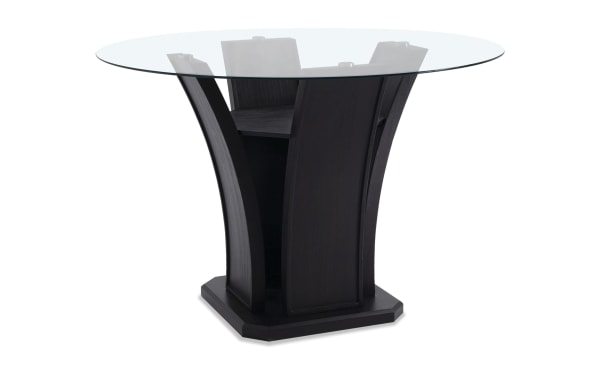 Contemporary Cosmopolitan dining table with round tempered glass top, deep espresso tulip base in rubberwood and acacia veneer, gray velvet upholstery.
