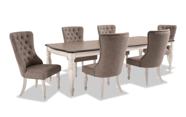 Scarlett 7 Piece Cottage Dining Set with beige polyester upholstered tufted chairs and extendable white and oak veneer table with carved legs.