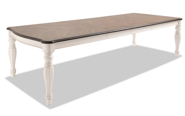 Scarlett cottage style extendable dining table with beige wire brushed oak veneer top, carved white poplar legs, and antique finish.